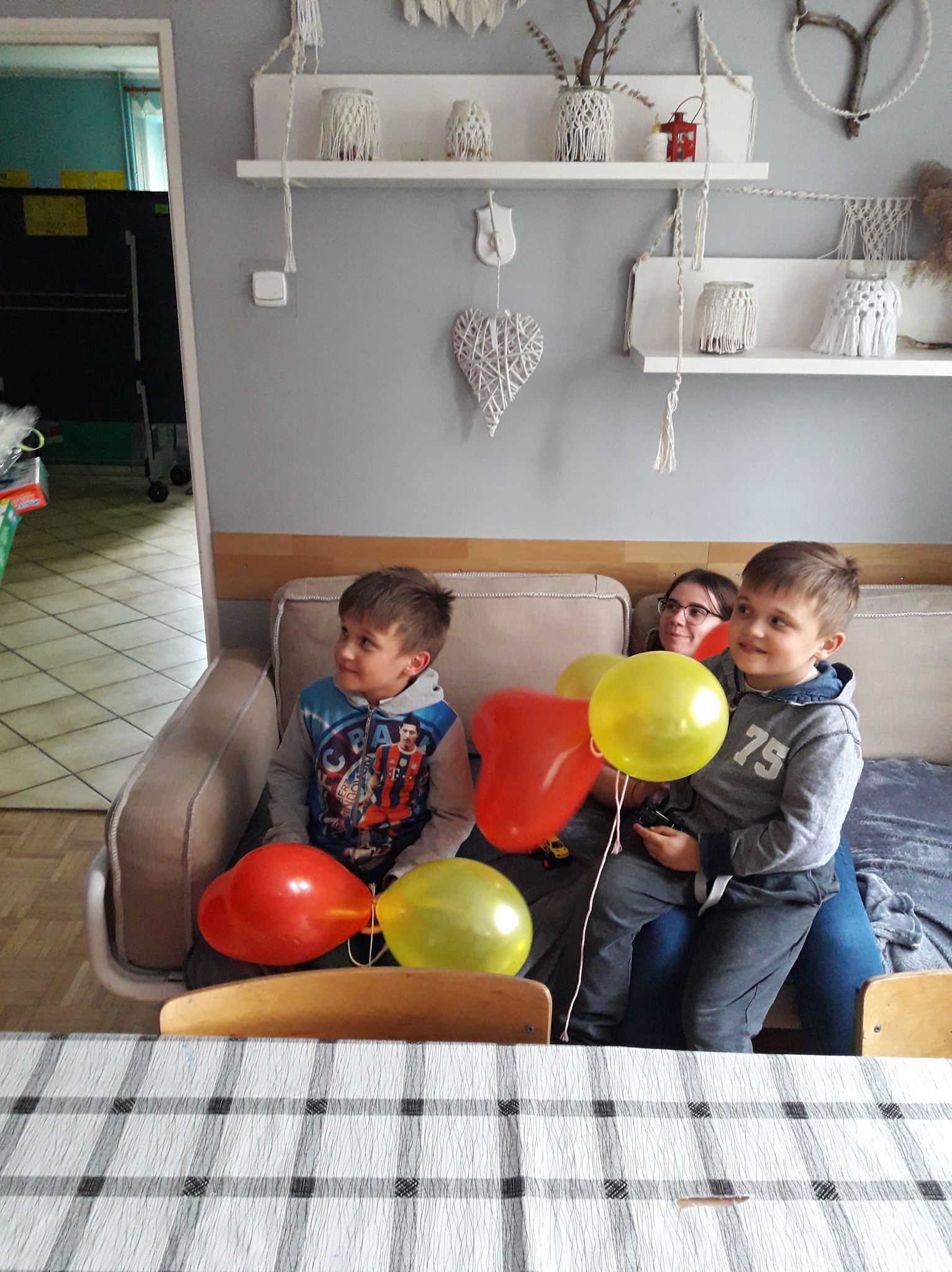 dzieci z balonami na kanapie czekają na prezenty