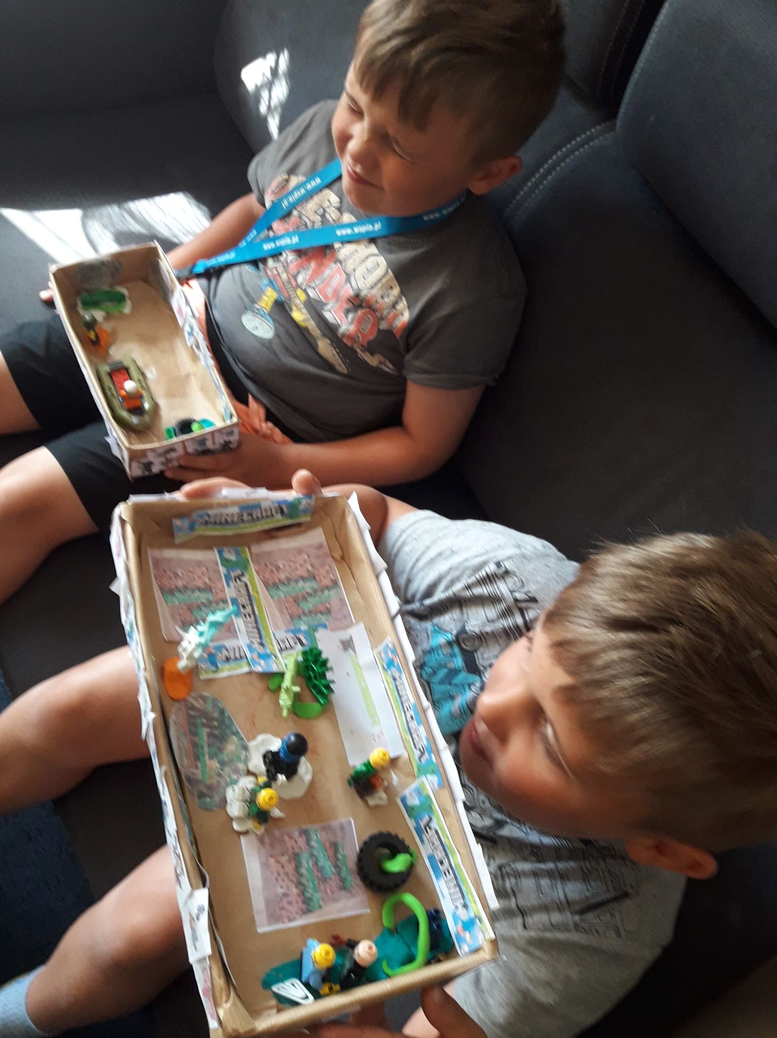 Julek i Natan siedzą ze swoimi pudełkami