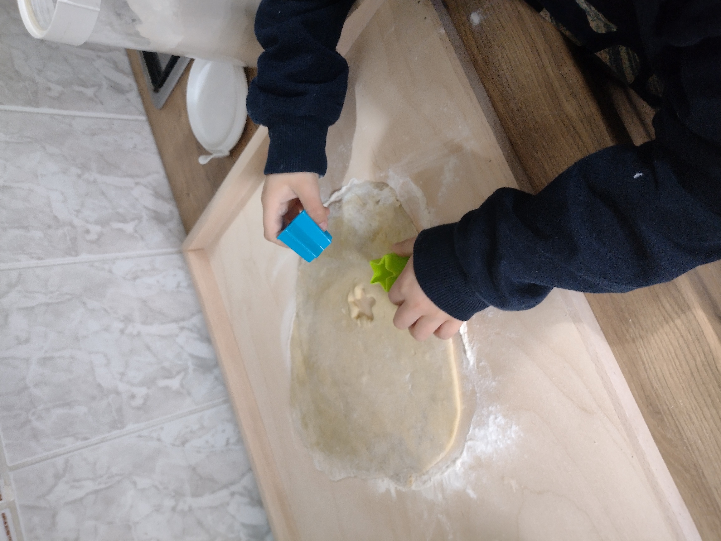 wychowanek wykrawa foremką kształty z ciasta