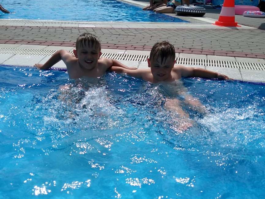 chłopcy machają nogami we wodzie