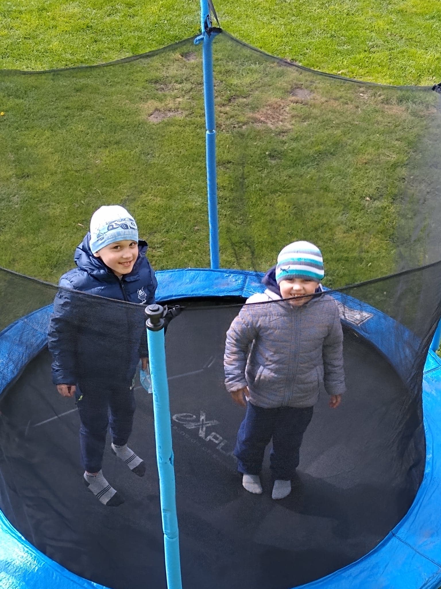 dwaj chłopcy skaczą na trampolinie