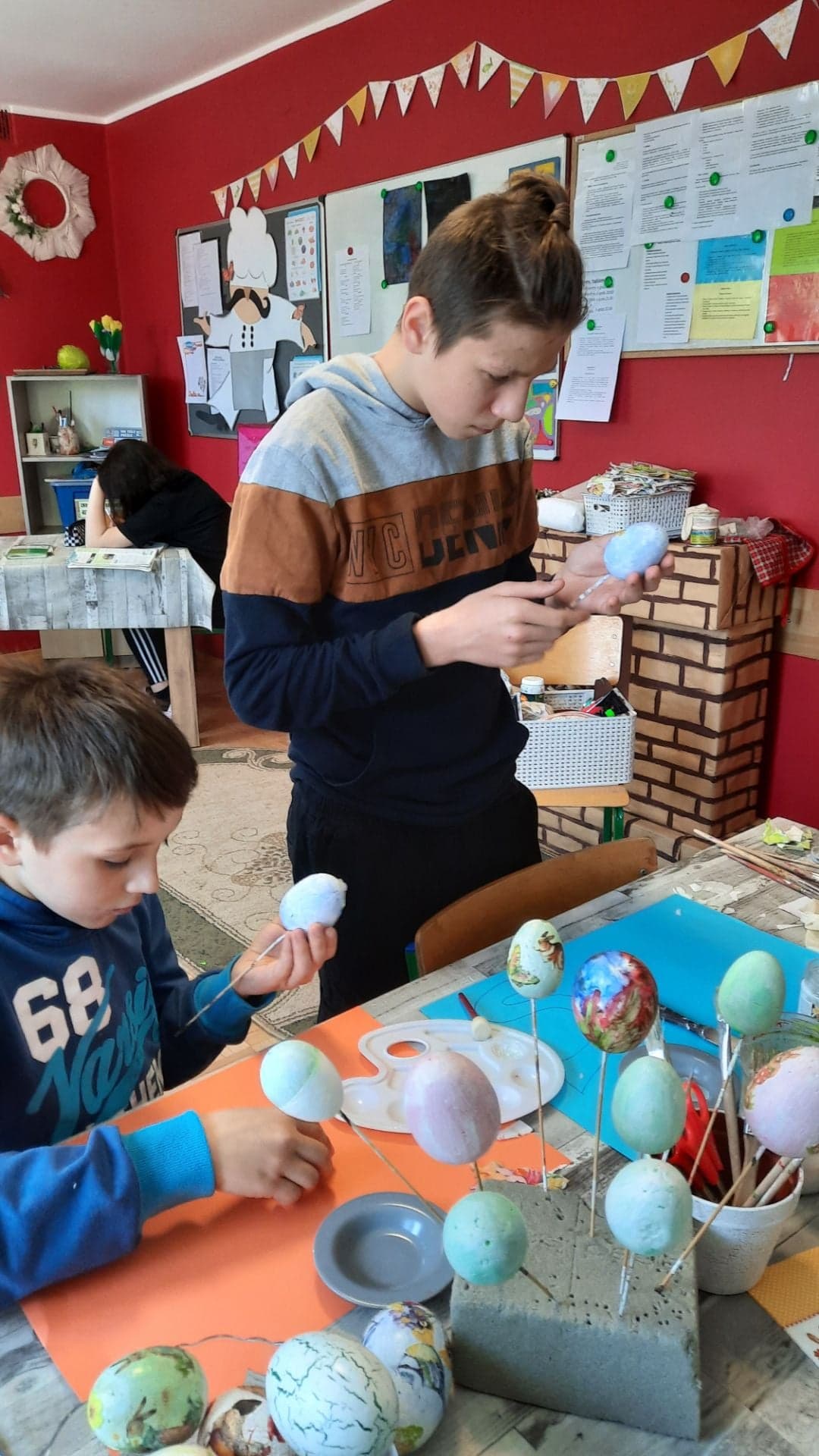 wychowankowie malują styropianowe jajka